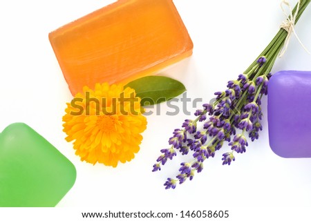 Handmade glycerin soaps with flowers on white background. Natural beauty care - lavender and marigold (Calendula officinalis).