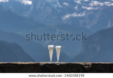 Two glasses of champagne with snowy mountains as background