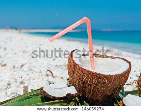 plastic straw in a coconut by the shore Royalty-Free Stock Photo #146059274