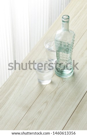 A Glass and a Bottle of water on the wood table