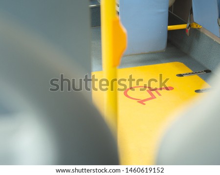 Close-up handicap logo in a bus. Priority seat for disabled people. Wheelchair accessible transportation concept.