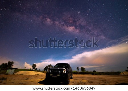 Starry night with Milky Way at Kudat Sabah Malaysia. Image contain soft focus and blur due to wide aperture and long exposure. image also contain grains and noise due to high ISO. With black car. 