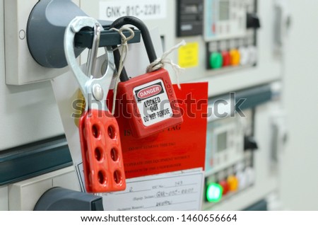 Red key lock and white tag for process cut off electrical on control panel in substation at chemical plants, power plants, oil & gas industry or onshore industry. isolation tag and do not remove tag. Royalty-Free Stock Photo #1460656664