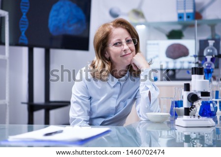 Portrait of middle age scientist thinking about her career at her office in a hospital laboratory. successful scientist. Royalty-Free Stock Photo #1460702474