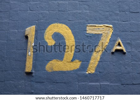 Number 127 a , street number plate on a facade.