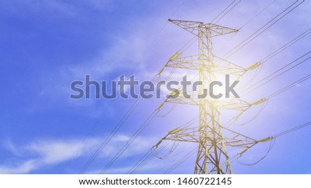 High voltage post or high voltage tower with light flare on blue sky cloudy background view. Outdoors. Transmission of High voltage with copy space.