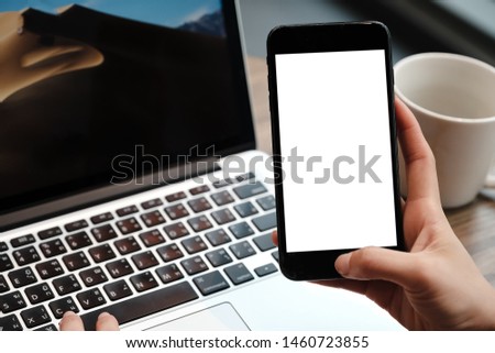 Close up of woman using blank cell phone and credit card sending massages on the coffee shop.