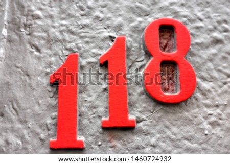 Number 118, street number plate on a facade.