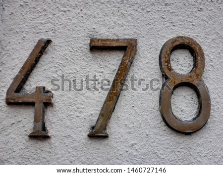 Number 478 , street number plate on a facade. Royalty-Free Stock Photo #1460727146