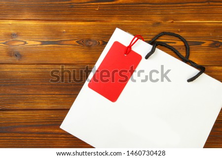 Paper bag on wooden  background with sale tag .  Mockup for design - Image 
