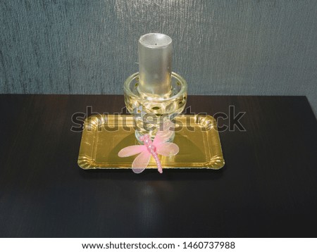 decorative candle with pink butterfly on golden tray