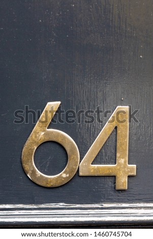 House number 64 on a black wooden front door