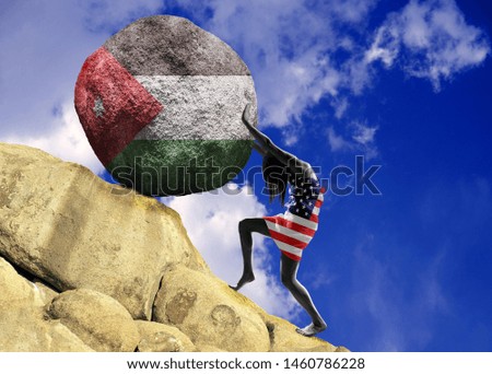 The girl, wrapped in the flag of United States of America, raises a stone to the top in the form of a silhouette of the flag of Jordan