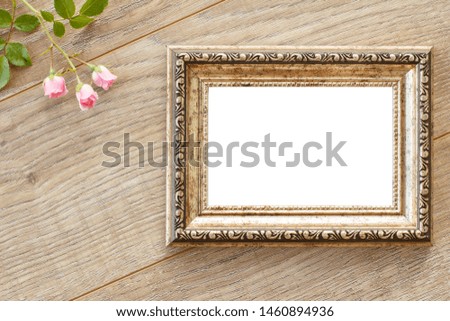 Vintage photo frame with copy space and rose flowers on old wooden boards.