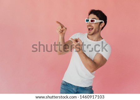excited muscular man in 3d glasses pointing with fingers isolated on pink