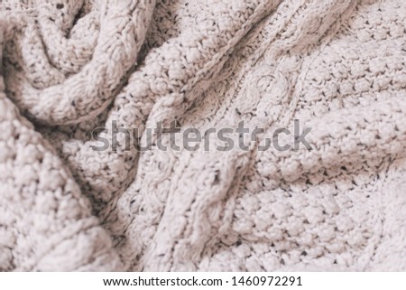  
texture of a beige knitted sweater with patterns