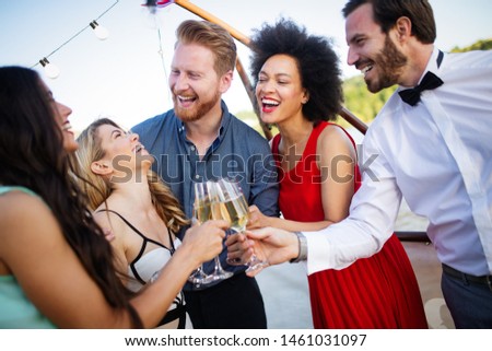 Group of friends drinking, chatting and having a fun at outdoor party