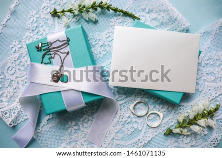 wedding invitation. gift box of blue color, white flowers and an envelope on a blue background