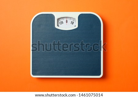 Blue weigh scales on orange background, top view Royalty-Free Stock Photo #1461075014