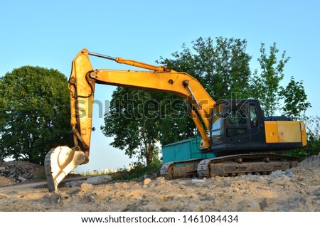 Excavator at a construction site during earthworks and laying of underground pipes. Professional excavation contractor serving, trenching, grading for residential, commercial, and municipal projects