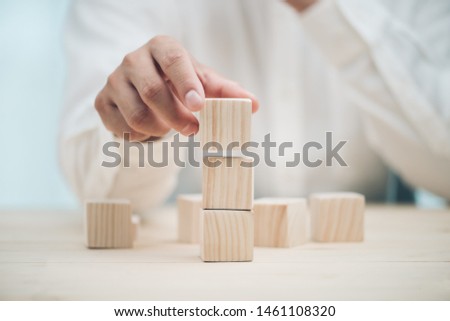 Hand arranging three wood cube stacking. Business concept growth success,hand stack woods block step on table. business development concept.copy space. Royalty-Free Stock Photo #1461108320