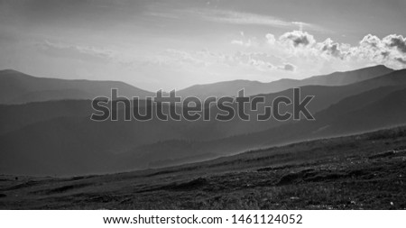 a beautiful black and white photo with valleys, hills and mountains covered in the fog. In a rural area of France