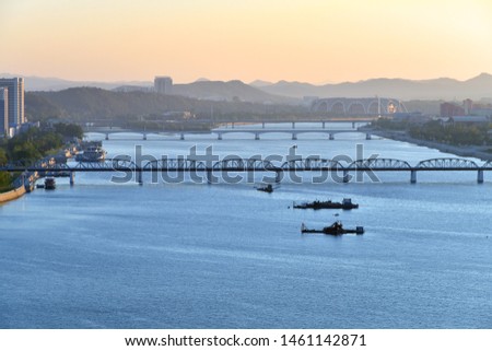 Pyongyang, DPR Korea North Korea and Taedong River in the sunrise. View facing upstream, modern residential complex, Taedong bridge and May Day Stadium from the Yanggakdo island Royalty-Free Stock Photo #1461142871