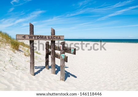 Sand dune tourist trail sign wooden gate to Wydma Lacka - largest sand dune in the park, Slowinski National Park near Leba, Baltic Sea, Poland 