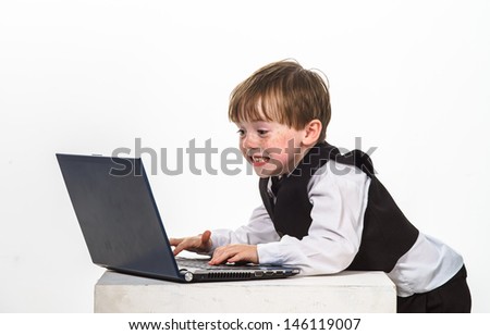 Freckled red-hair little boy with laptop. Isolated on white background.