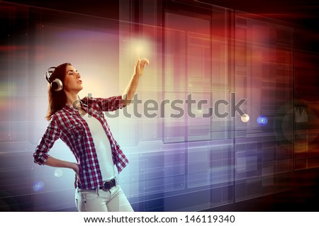 Image of young woman with headphones touching virtual screen