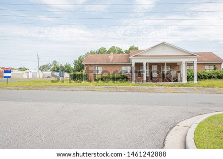 A rundown residential and commercial property in a suburban area with a for lease sign.