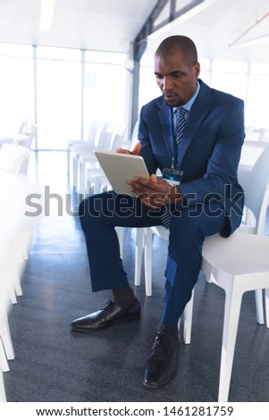 Front view of African-american Male speaker practicing his speech on digital tablet in business seminar at conference room. International diverse corporate business partnership concept Royalty-Free Stock Photo #1461281759