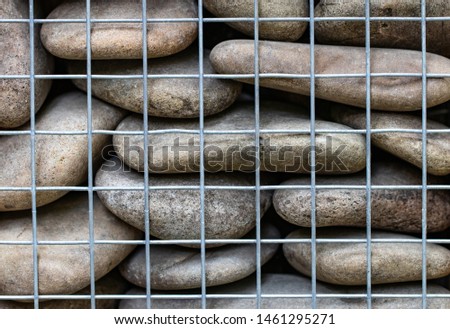 abstract background with  stones behind the net fence close-up.