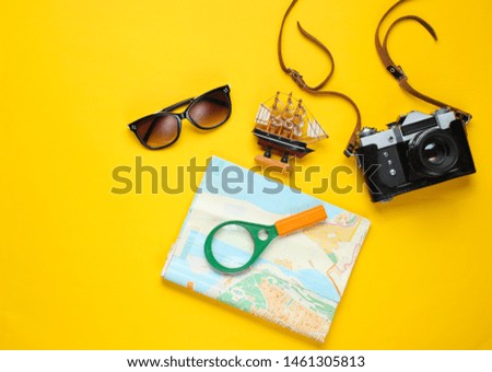 Traveler accessories, retro camera on a yellow background. Trip on the beach, vacation. Summer minimalistic background. Flat lay tourism allegory.
Top view