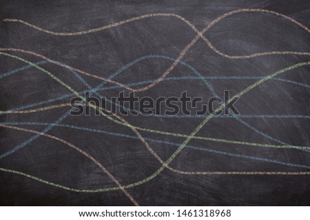 Abstract colorful wavy lines of crayons drawn by children on chalkboard, representing free hand drawing educational concept