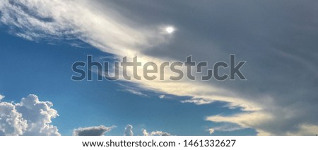 dark blue sky and sun through dark clouds