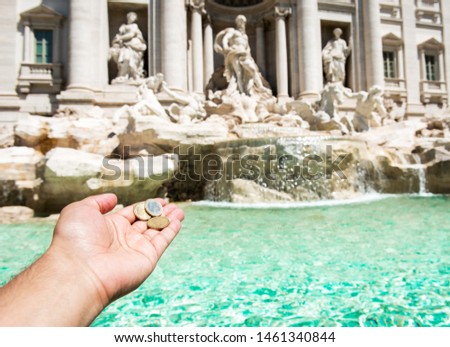 Man is throwing coin at Trevi Fountain for good luck. A man hand keeping coin. Trevi Fountain, Rome, Italy. 
 Royalty-Free Stock Photo #1461340844