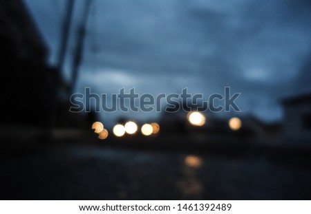Blurred image showing car lights on a highway just after sunset.