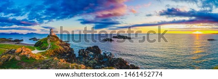Sunset panorama of Lighthouse on Llanddwyn Island at the coast of Anglesey in North Wales,UK Royalty-Free Stock Photo #1461452774