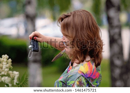 young girls take pictures of each other in the park