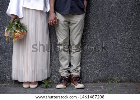 couple holding hand in the wall with bouquet of flowers. Wedding pre wedding themed, indonesian couple. Pictures of love