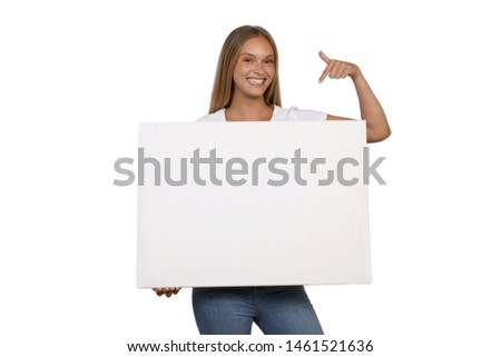 Young woman is smiling and pointing to a blank white board in the hand
