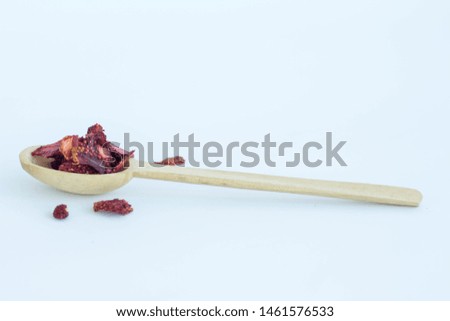 Dry strawberry and a wooden spoon isolated