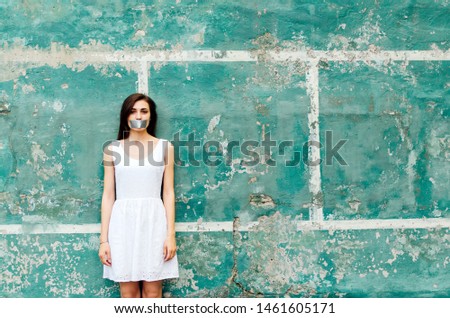 Portrait of woman with taped mouth