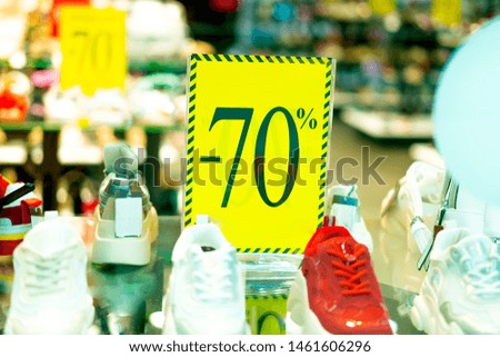 Sale sign 70 percent in a fashion clothes shop display window 