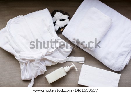 Folded spa bathrobe and towels on sofa