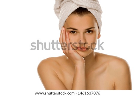 Young bored woman with towel on her head on white background