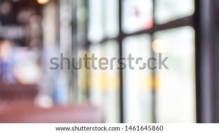 Close up blur of atmosphere in coffee shop cafe by the window with peoples(customer) on scene bokeh background view. Indulge of deep coffee with lazy day. Abstract texture pattern of the Interior.