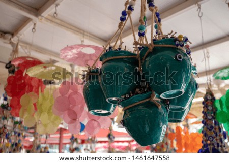 Flower pots in blue color. Pots in rope and evil eye beads. Blurred background. Taken inside the store.