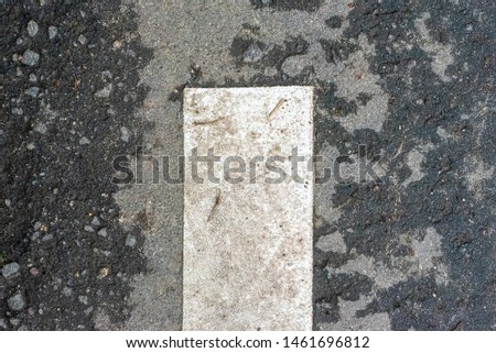 Fragment of road markings at the curb. Fragment of a white stripe on asphalt. Abstract background.